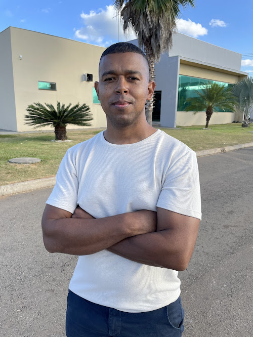 Foto de Maycon Rocha, usando uma camiseta de cor vemelha.